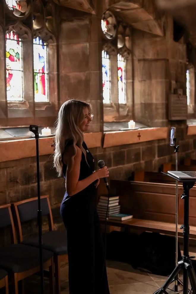 Caitie holding a microphone inside a church