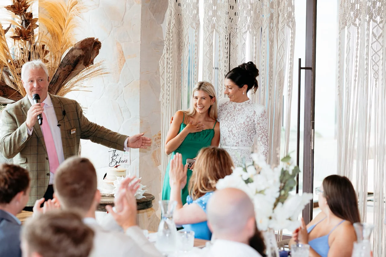 Caitie sharing a moment with a bride as wedding guests applaud